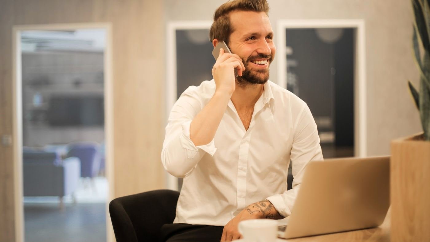 A small business owner taking a call at his desk