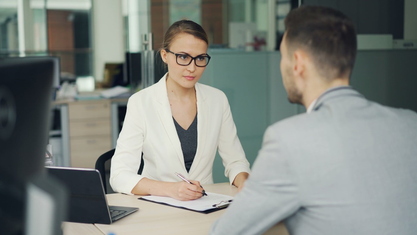 Two colleagues talking over a desk